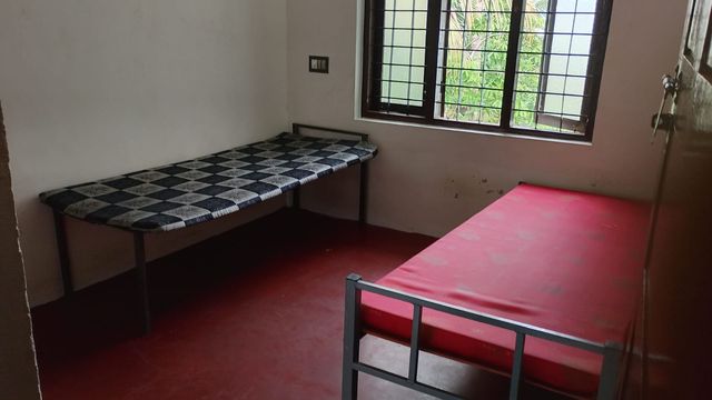 Twin-sharing room with two cots and mattresses at Ashraf Gents Hostel, NAD Road, Kalamassery