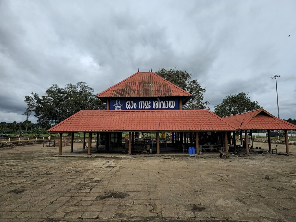 The Aluva Manappuram Siva temple with its tiled roof on the sandy riverbank